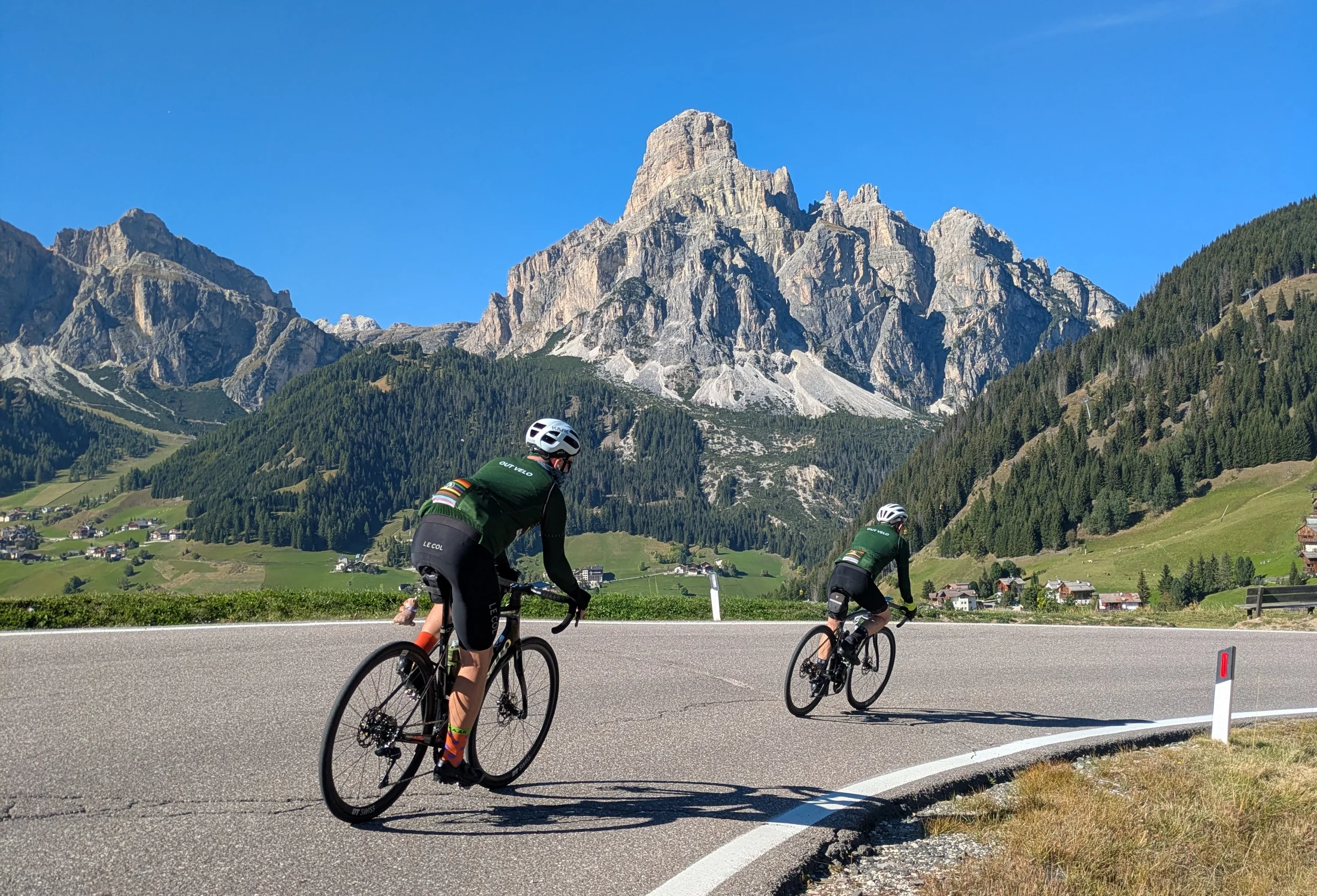 Out Velo riders cycling beneath the Dolomites