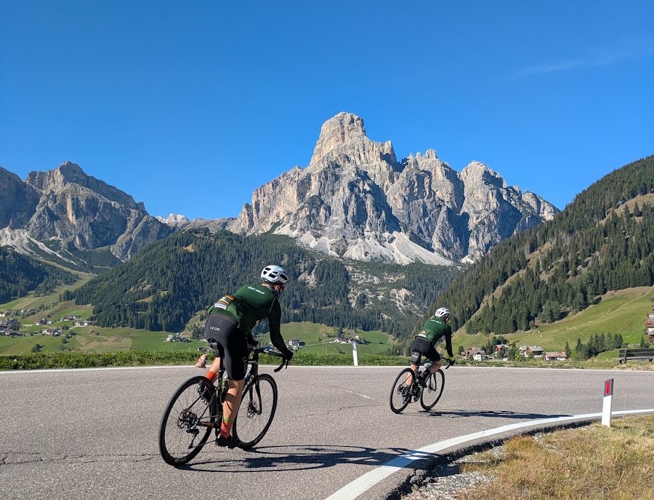 Out Velo riders cycling beneath the Dolomites
